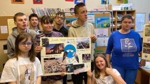 uczniowie prezentują plakat z okazji Dnia Ziemi