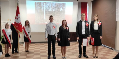 Milena,Andrzej, Zuzanna i Bartek i uczniowie ze sztandarem szkoły w czasie słuchania piosenki