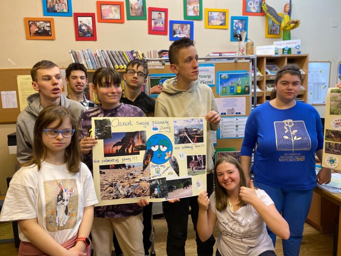 uczniowie prezentują plakat z okazji Dnia Ziemi